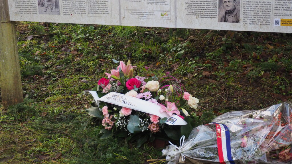 La gerbe de fleur qui a été déposée au pied de la plaque racontant l'histoire d'Addi Ba